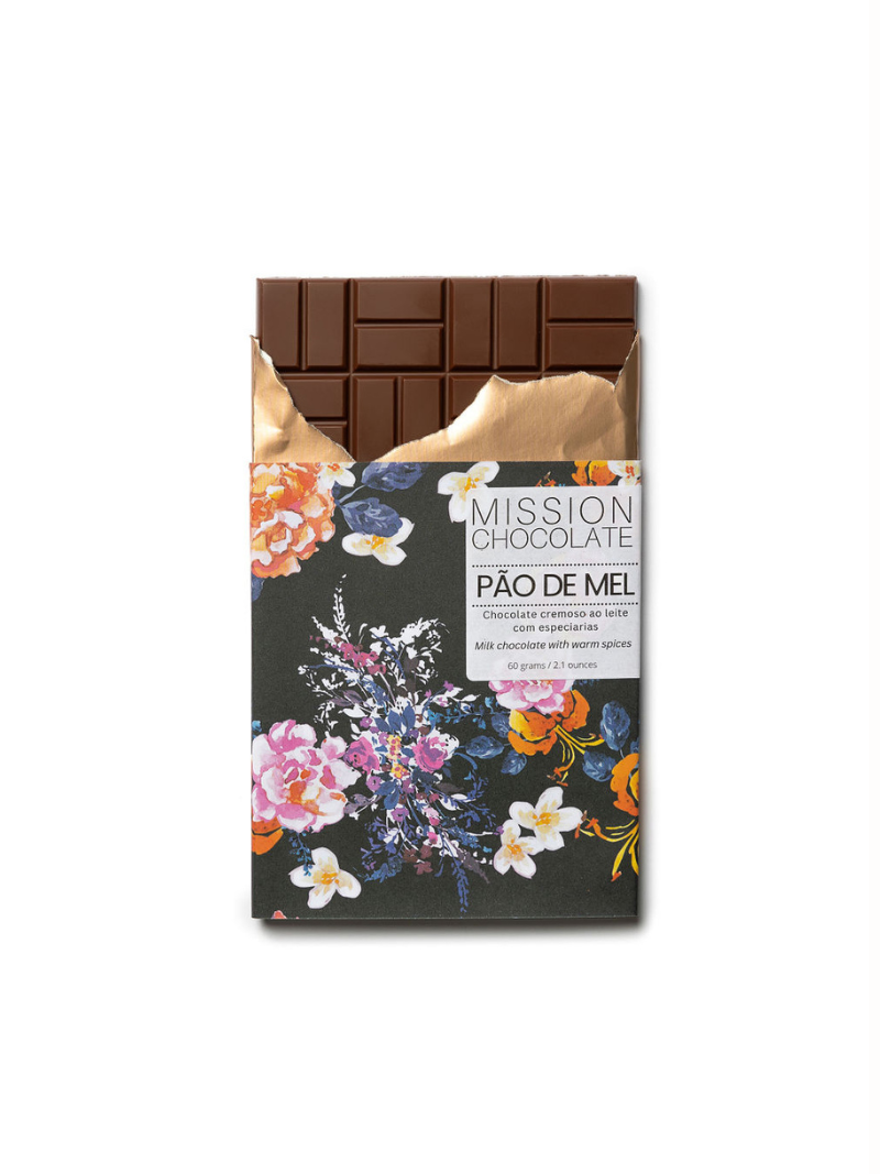 Embalagem do chocolate de pão de mel, florida com um fundo azul-escuro, sobre um fundo branco. Metade do chocolate está para fora da embalagem.